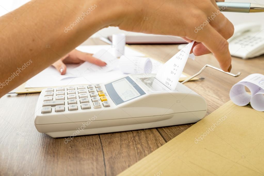 Bookkeeper doing calculations on an adding machine