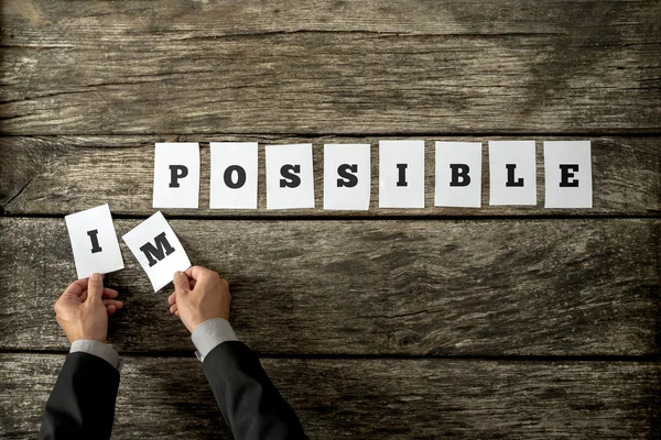Empresário tirando cartas IM da palavra "impossível" — Fotografia de Stock