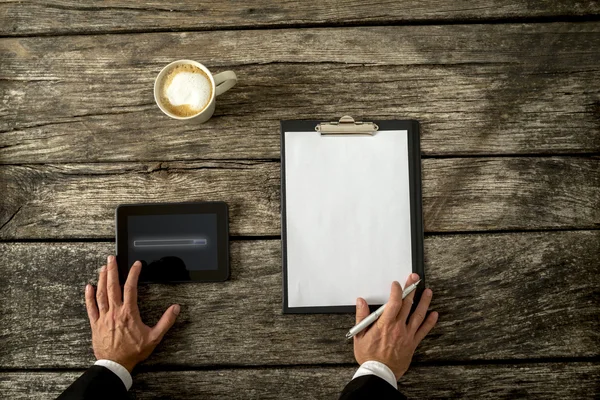 Uomo d'affari con tavoletta, carta e caffè in tavola — Foto Stock