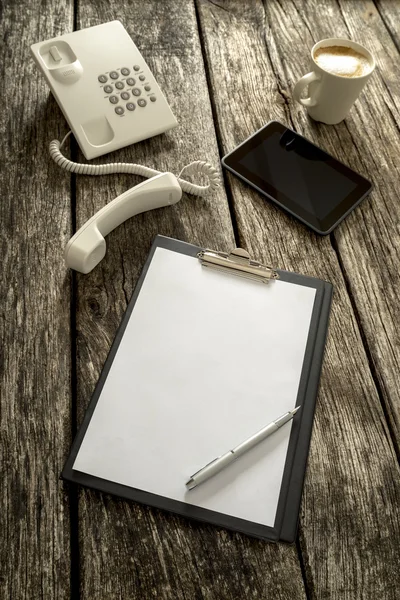 Telefon, Tablet, Kaffee und Papier auf dem Tisch — Stockfoto