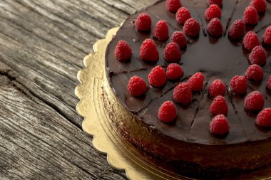 Overhead view of tasty raw chocolate cake decorated with raspber