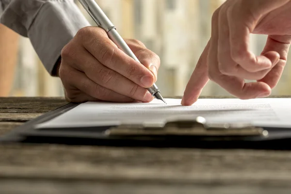 Nahaufnahme eines Arbeitgebers, der seinem neuen Mitarbeiter zeigt, wo er einen Vertrag unterschreibt — Stockfoto