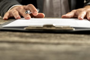 Closeup of male hand about to sign a subscription or application