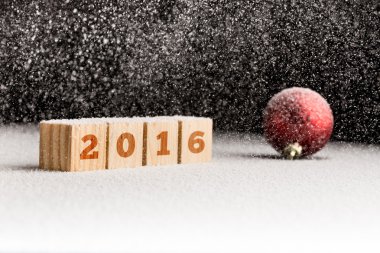 ahşap küpleri ve bir kar üzerinde yalan kırmızı Noel top 2016 imzalamak