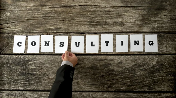 Business consultant assembling the word CONSULTING — Stock Photo, Image