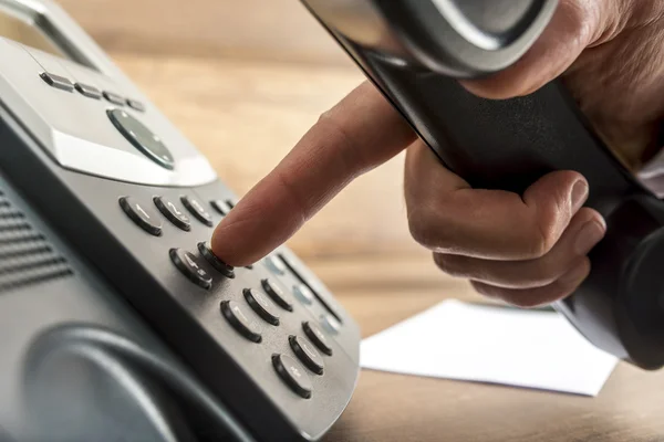 Closeup of male hand dialing a telephone number on black landlin — Stock Photo, Image