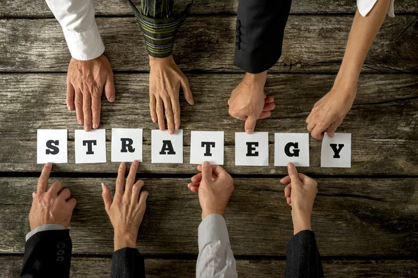 Top view of eight business people assembling the word STRATEGY — Stock Photo, Image