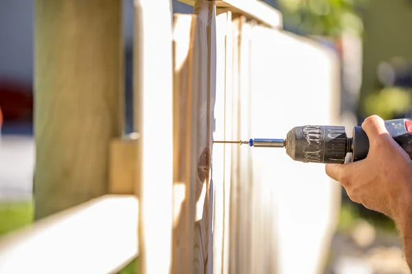 Hombre erigiendo una valla de madera al aire libre — Foto de Stock