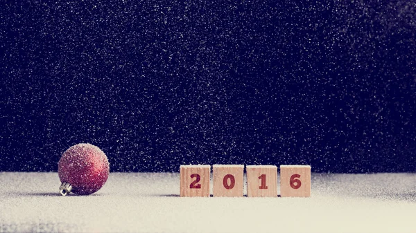 2016 fundo do Ano Novo com neve caindo sobre um Natal vermelho — Fotografia de Stock