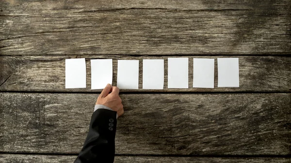 Bovenaanzicht van mannenhand in elegante bedrijf passen plaatsen seve — Stockfoto