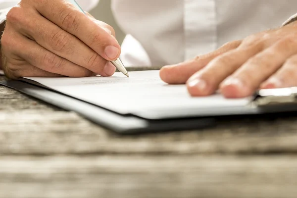 Vista de ángulo bajo del contrato de firma de mano masculina o suscripción para —  Fotos de Stock