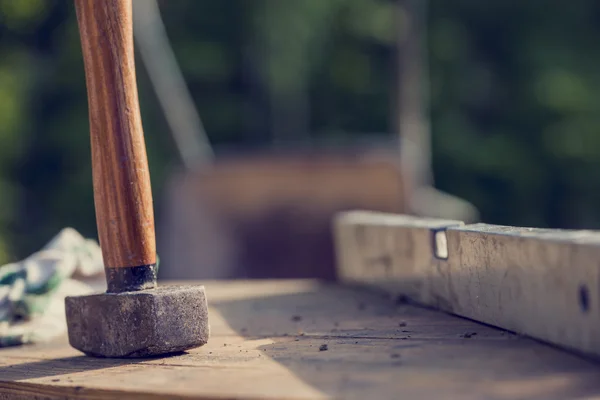 Conceito de canteiro de obras com um martelo de madeira e nível — Fotografia de Stock