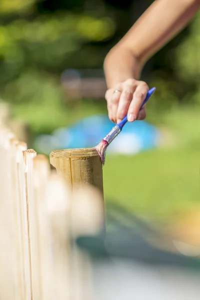 Wanita memvariasikan pagar kayu di luar ruangan di teras rumah — Stok Foto
