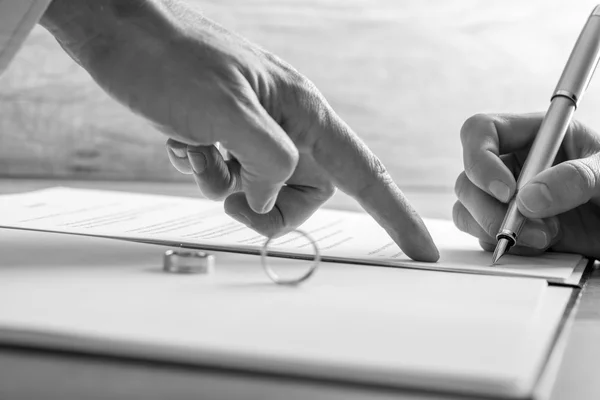 Male hand pointing to a woman where to sign legal divorce papers — Stock Photo, Image