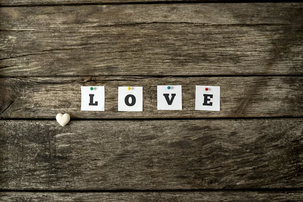 Mot amour orthographié avec des cartes blanches individuelles épinglées à un textur — Photo
