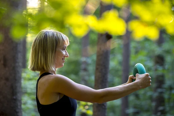 Young blonde woman doing pilates power exercise bending a rubber — Stock Photo, Image