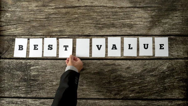 Salesman assembling a Best value sign — Zdjęcie stockowe