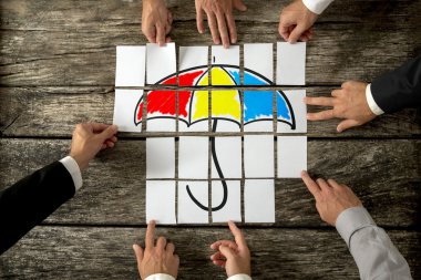 Top view of eight male hands assembling a colourful umbrella wit