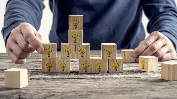 Vista frontale di un uomo che organizza blocchi di legno con grida disegnate a mano — Foto Stock