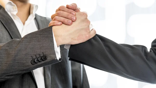 Close up of two businessmen in gray business suit gripping their — 图库照片