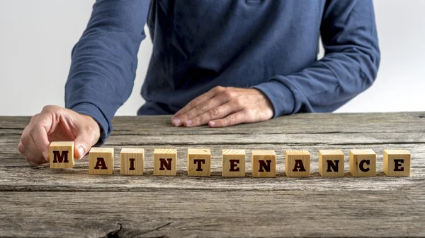 Vue de face d'un homme assemblant le mot Maintenance — Photo