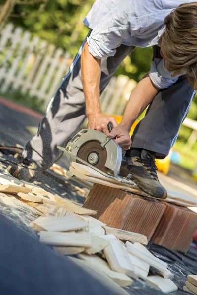 Young man working in his back yard using circular saw — Stock Photo, Image