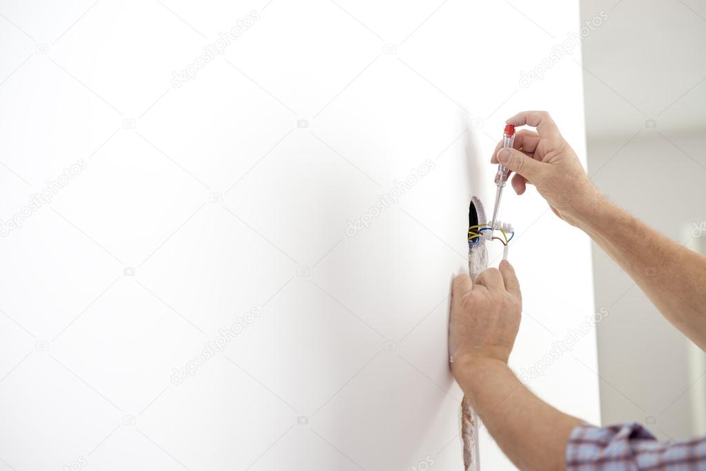 Electrician checking the presence of electrical current in a new