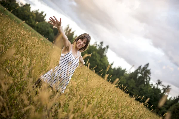 Junge Frau steht mit hohem Tempo mitten auf der Herbstwiese — Stockfoto