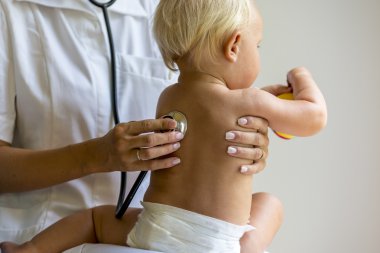 Akciğerlere dinlemek için bir stetoskop kullanarak Pediatrik tıp doktoru 