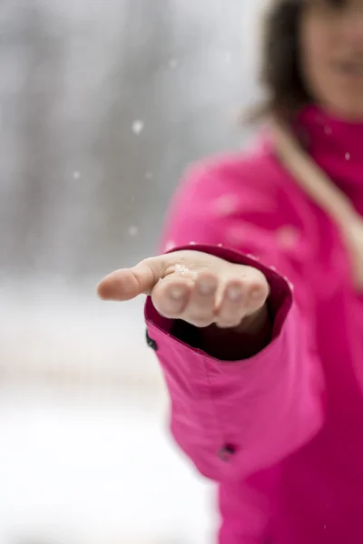 Primer plano de la mano femenina la captura de copos de nieve que caen del cielo —  Fotos de Stock