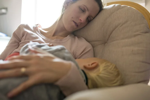 Ung mamma tupplur i en gungstol med babyn som låg i h — Stockfoto