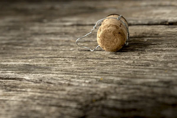 Champagne cork lying on a wooden board — Stock Photo, Image