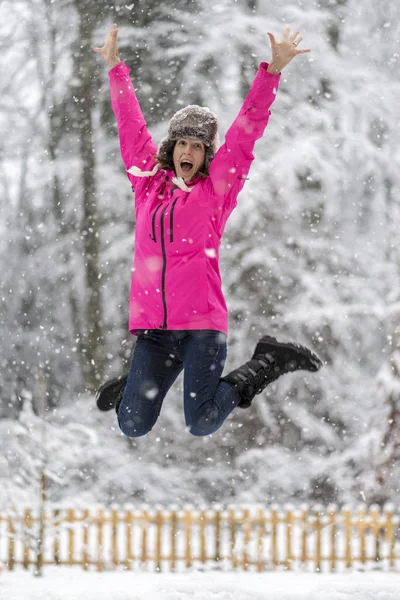 Happy cheerful young woman jumping high up in the air lifting he — Stock Photo, Image