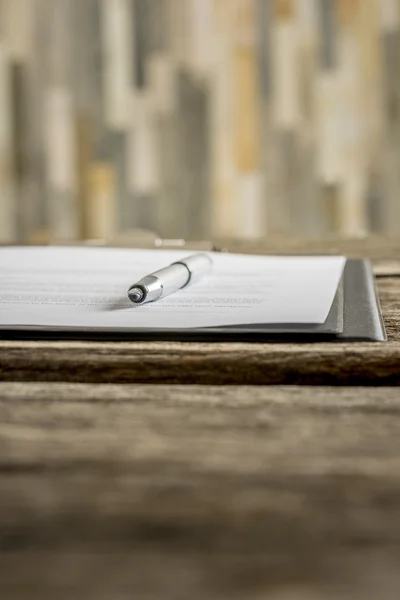 Low angle view of ink pen lying on a document in folder — Stock Photo, Image