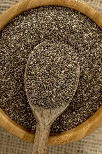 Wooden spoon in a bowl full of nutritious chia seeds — Stock Photo, Image