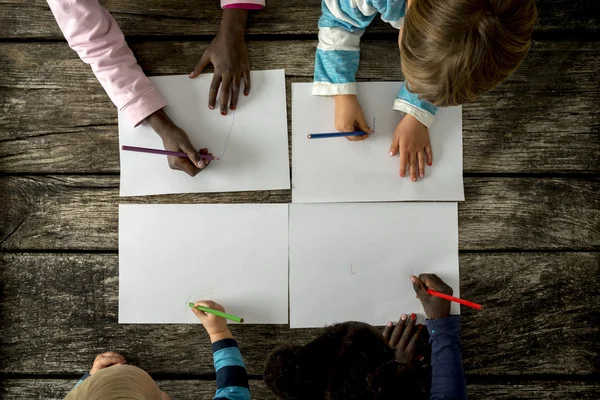 Vista dall'alto di quattro bambini, ragazzi e ragazze di razze miste, drawin — Foto Stock