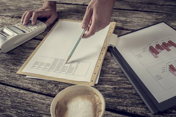 Mannelijke financieel adviseur naar statistische gegevens num met pen — Stockfoto