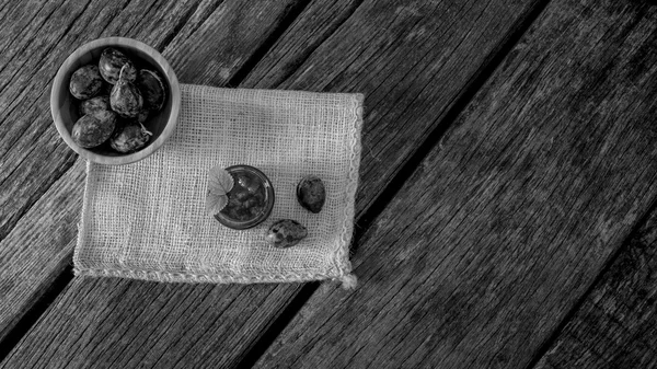 Prunes fraîches dans un bol en bois à côté d'un bocal en verre plein de ma maison — Photo