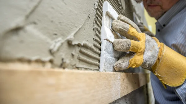 Nahaufnahme eines Arbeiters, der sorgfältig eine Zierfliese in einem — Stockfoto