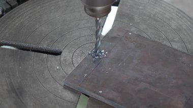 Matkap metali deliyor, makine metalde bir delik açıyor.