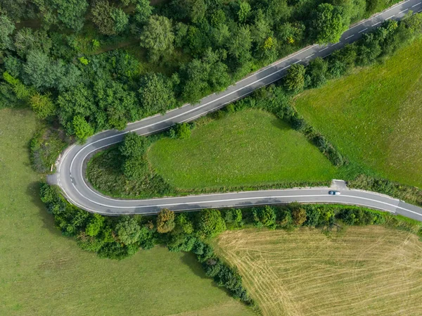 从空中俯瞰山中灌木丛和树木附近的公路硬弯道 — 图库照片