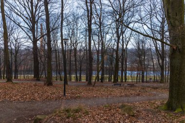 Parkın arkasındaki küçük nehrin etrafında fenerler ve banklar var.