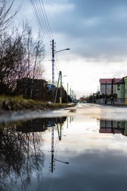 Zawiercie, Polonya - 18 Şubat 2020 Long Caddesi bulutlu gün batımında su birikintisine yansıdı