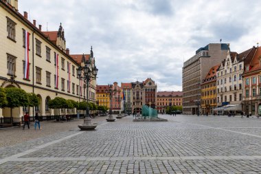 Wroclaw, Polonya - 03 Mayıs 2020: Bulutlu güneşli bir günde eski renkli apartman evleriyle dolu Pazar Meydanı