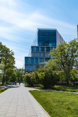 Wroclaw, Polonya - 8 Mayıs 2020: Thespian iş merkezi binasına kadar ağaçlar ve çalılarla dolu uzun bir yol 