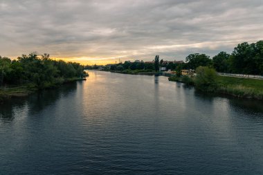 Wroclaw, Polonya - 19 Mayıs 2020: Bulutlu bir öğleden sonra Odra nehrinin üzerinde renkli bir günbatımı