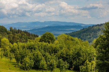 Panorama of Rudawy Janowickie with Big glade full of grass and trees around 