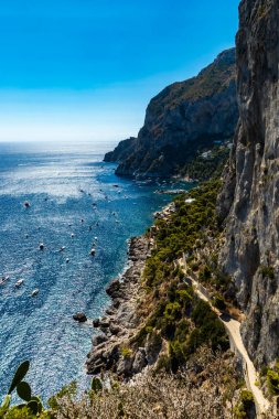 Capri adasının yanındaki küçük gemi ve teknelerle dolu küçük körfezin uçurumundan güzel bir manzara. 