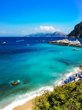 Capri, İtalya - 24 Ağustos 2020: Teknelerle dolu liman kasabasının yanındaki Capri Adası 'nda küçük plajlı sahil