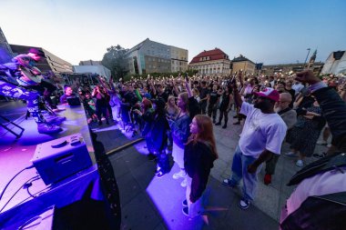 Wroclaw, Polonya - Eylül 12025: Dinamik konser ve No Longer Music NLM 'nin 2024 yılında Wroclaw' s Freedom Square 'deki performansı, hard rock' ı gospel ve artistik tiyatro ile harmanladı.